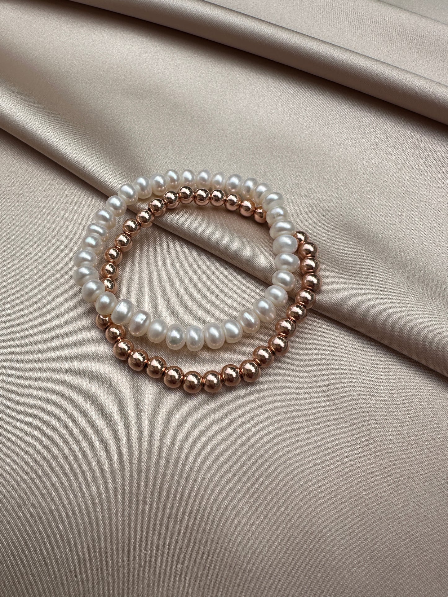 OS pair of white pearl bracelets.