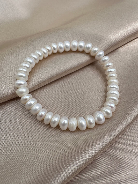 OS pair of white pearl bracelets.