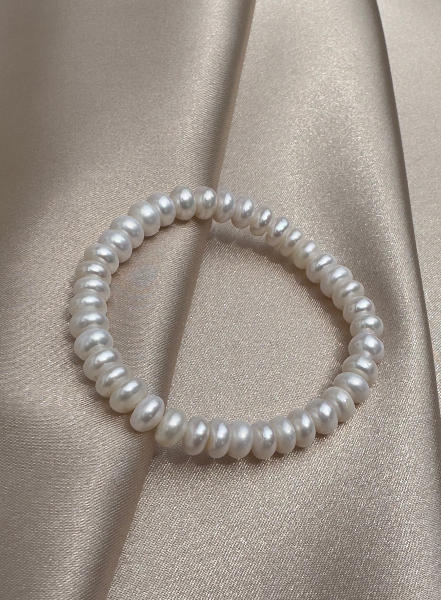 OS pair of white pearl bracelets.